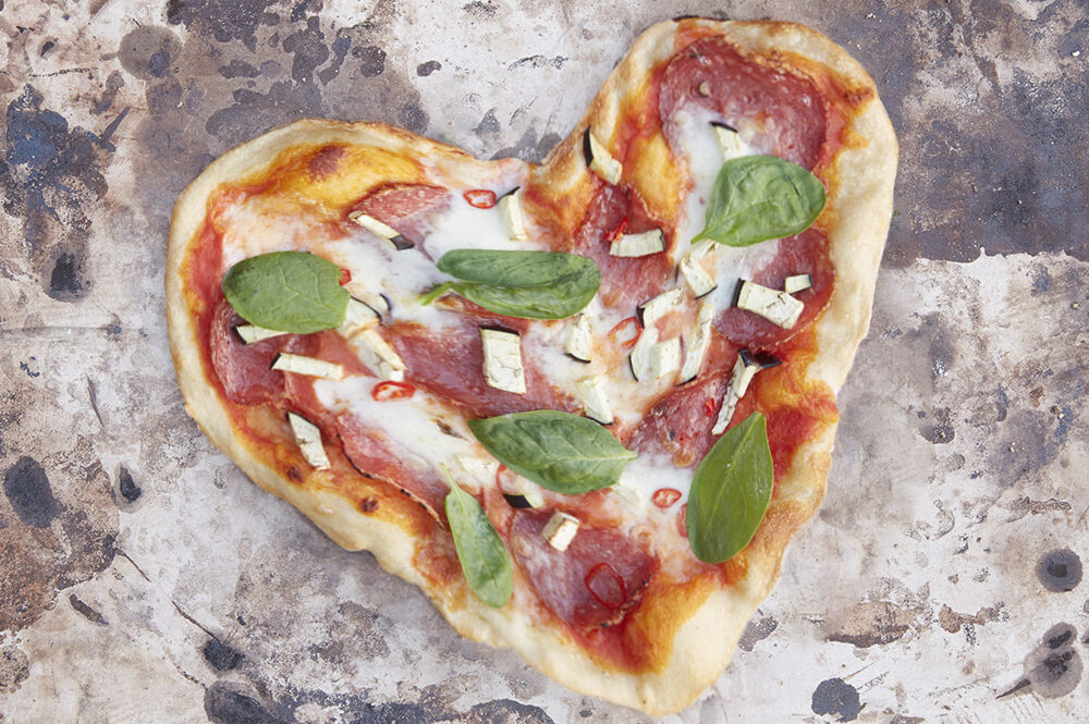 Pizza in Herzform für Valentinstag auf einem SANTOS Pizzastein