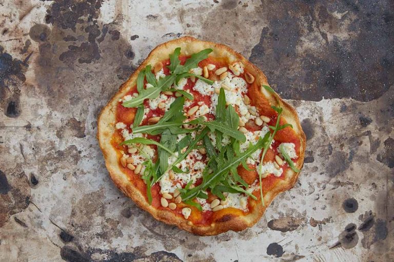 Pizzakreation: Rucola und Schafskäse