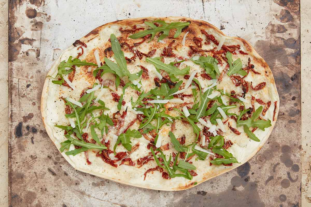 Flammkuchen Rucola, getrocknete Tomaten und Parmesan