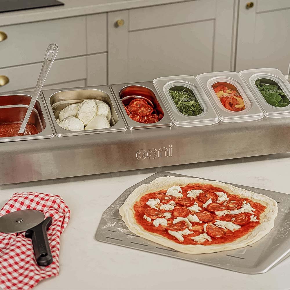 Ooni Pizzabelag-Station Edelstahl mit Pizzabelag gefüllt
